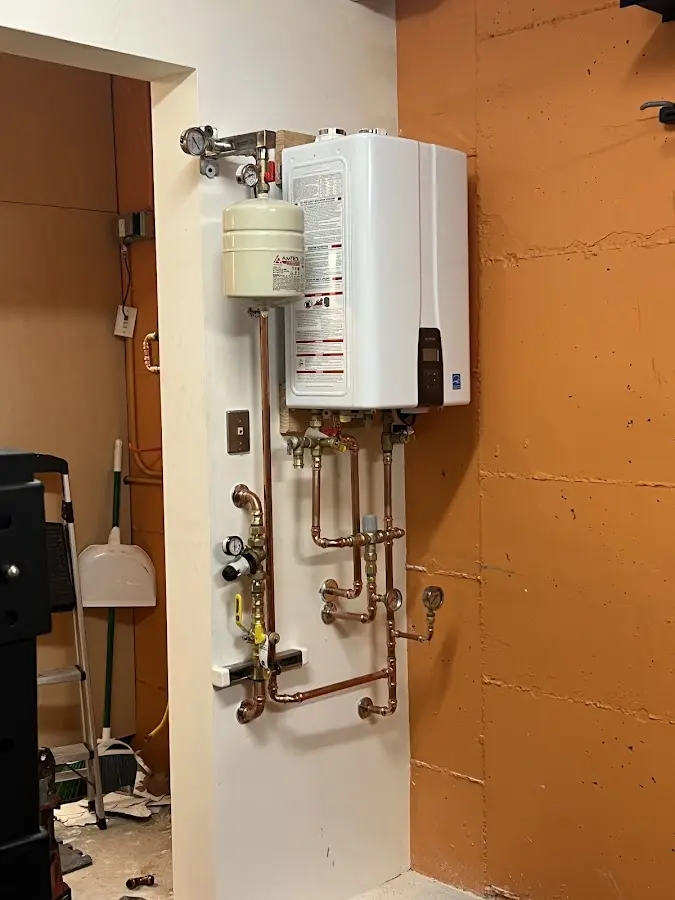 Plumbing technician inspecting water heater connections in Spring City